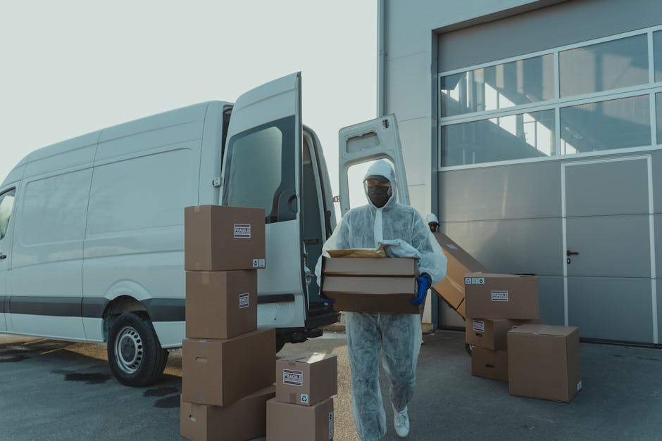 A delivery worker in PPE unloads boxes from a van. Efficient and safe logistics.